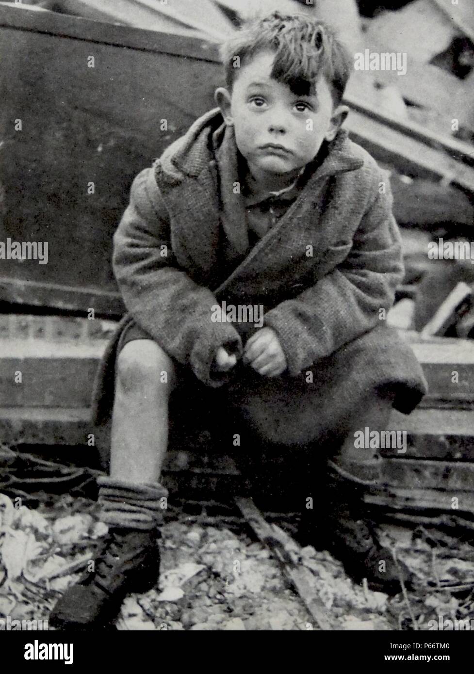 Un enfant orphelin a l'air choqué après avoir survécu au blitz sur Londres, par des fusées allemandes V2 1944 Banque D'Images