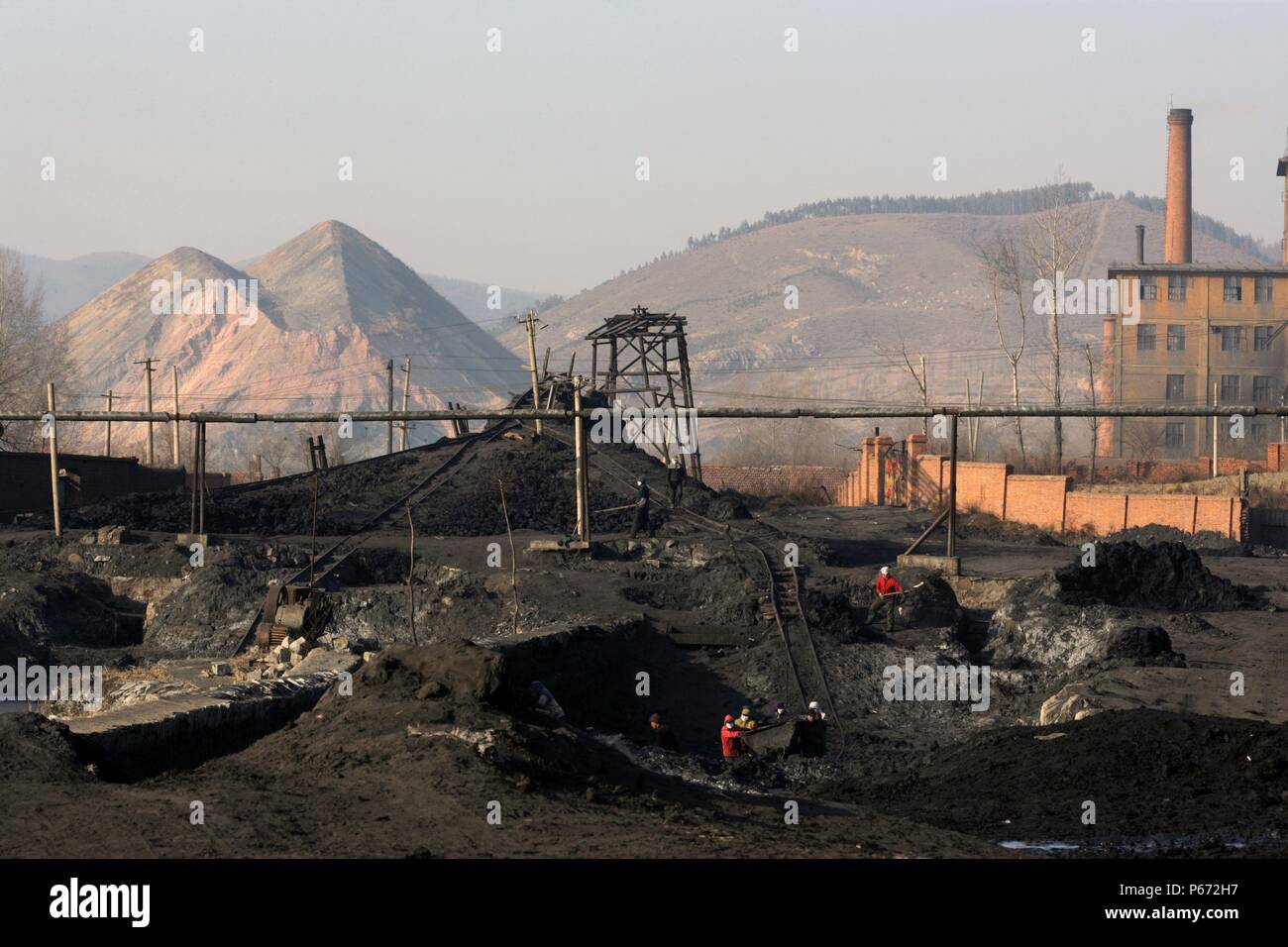 Un drame intemporel révolution Industrail comme ouvriers creusent la boue de charbon séché de la goulotte de remplissage d'étangs au nord-est de la Chine. Beichang Banque D'Images