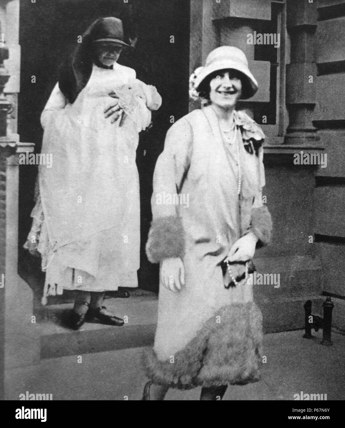 La duchesse d'York (plus tard la reine Elizabeth) promenades le long d'une infirmière, qui exploite la jeune princesse Elizabeth (plus tard la reine Elizabeth II), d'assister à l'inauguration du nouveau-né la princesse. Banque D'Images