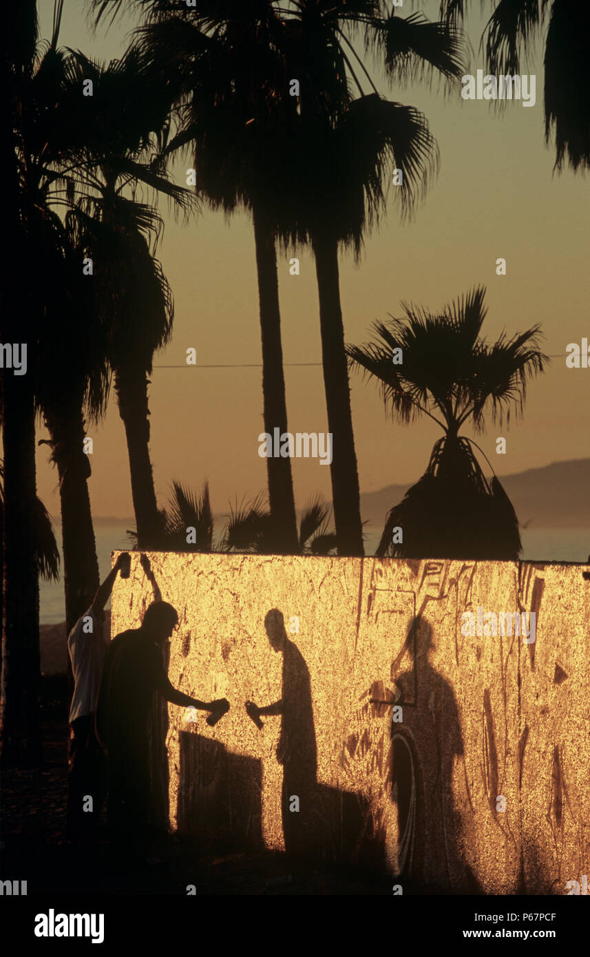 Les artistes de rue en utilisant la peinture en aérosol pour la création de murales sur un mur à Venice Beach, Los Angeles, USA Banque D'Images
