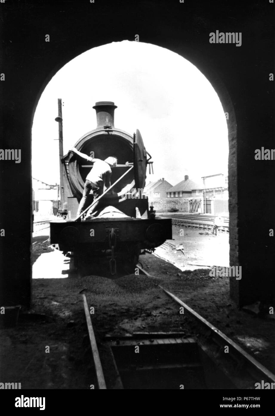 Pelleter des cendres chaudes de la boîte de fumée d'un ancien un LNER Q6 0-8-0 à West Hartlepool depot dans le milieu des années 1960. Banque D'Images