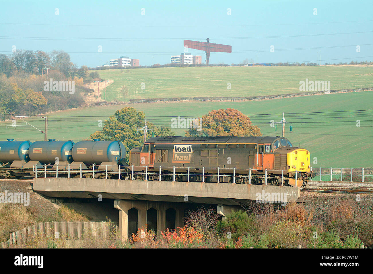 L'Ange du Nord domine le CELV et ici est veille sur un classe 37 dans charge livrée avec un train de transport de citernes. Novembre 2003. Banque D'Images
