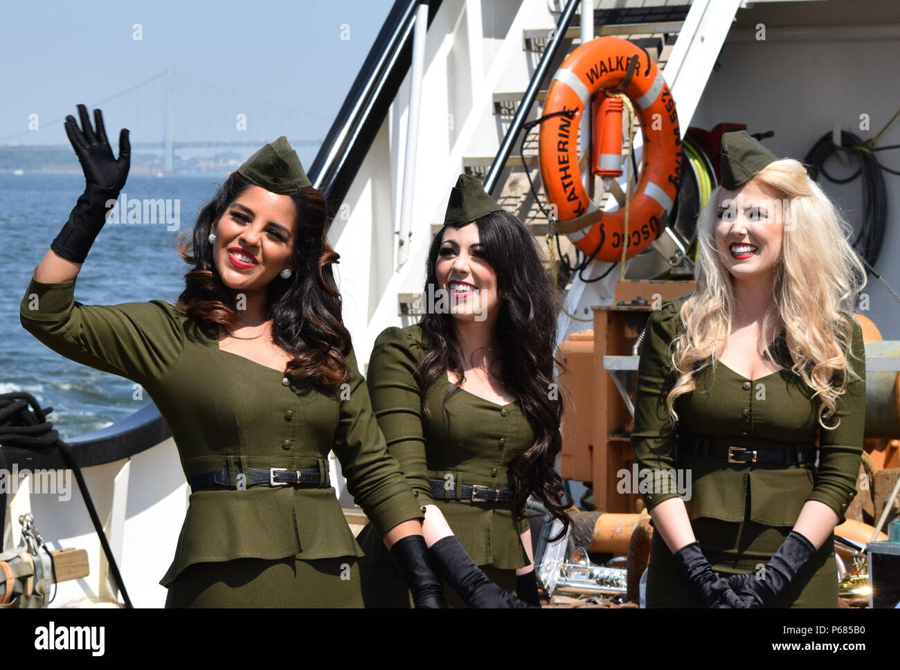 160525-N-WU551-267 NEW YORK (25 mai 2016) Gabriela Hernandez, Crystal Cimaglia et Lydia Pusateri, membres de l'American Bombes, une guerre mondiale II-style troupe, vague de fans après l'exécution à bord du garde-côte américain Katherine Walker (WLM) 552 comme ils naviguer sur le fleuve Hudson vers le pont Verrazano-Narrows dans la Fleet Week New York 2016 Défilé des navires. Plus de 4 500 marins, marines et gardes côte de 14 navires, y compris la Marine royale canadienne sont en ordre décroissant sur la ville pour FWNY, maintenant dans sa 28e année, à interagir avec les citoyens de New York et t Banque D'Images