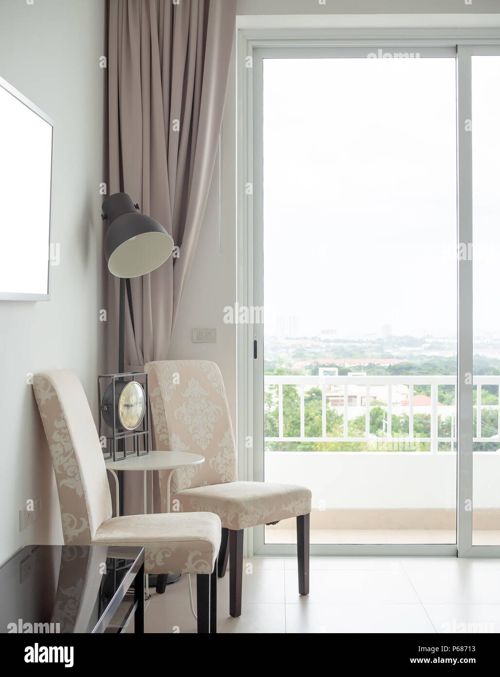 Modern Luxury White Salon intérieur avec cadre blanc sur le mur avec des chaises Vintage Vintage, réveil, table et lampe de plancher noir avec le rideau Banque D'Images