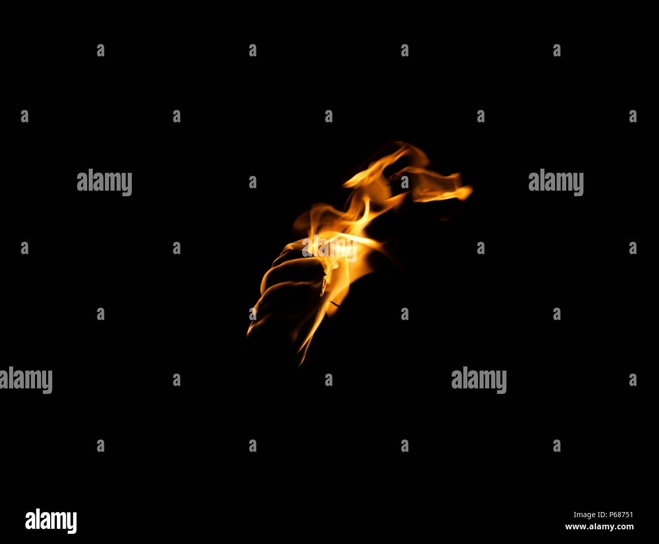 Flamme d'une torche dans le noir sur un fond noir, seul le feu est visible Banque D'Images