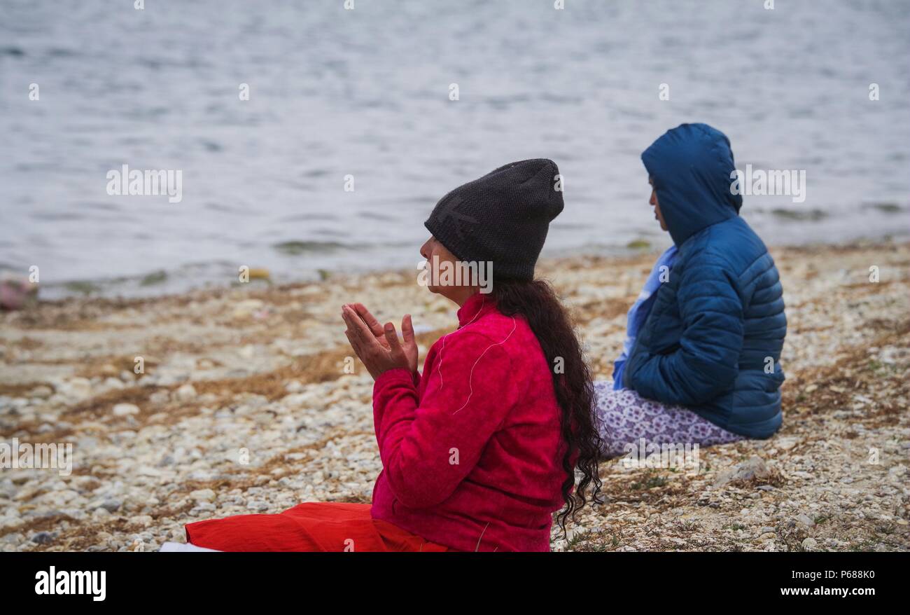 Ali, la Région autonome du Tibet. 26 Juin, 2018. Pèlerins indiens prier pour la bénédiction de la banque du Mapam Yumco Lake, un site bouddhiste et hindoue sacrée, dans la préfecture d'Ali, le sud-ouest de la Chine, région autonome du Tibet, le 26 juin 2018. Cette année, le Col Nathu La devrait voir officiellement environ 500 pèlerins de l'Inde organisé qui va prendre les 2 874 km de pèlerinage, selon Yang Zhigang, directeur adjoint du Bureau des affaires étrangères et des affaires chinois d'outre-mer dans la ville de Xigazê. Credit : Liu Dongjun/Xinhua/Alamy Live News Banque D'Images