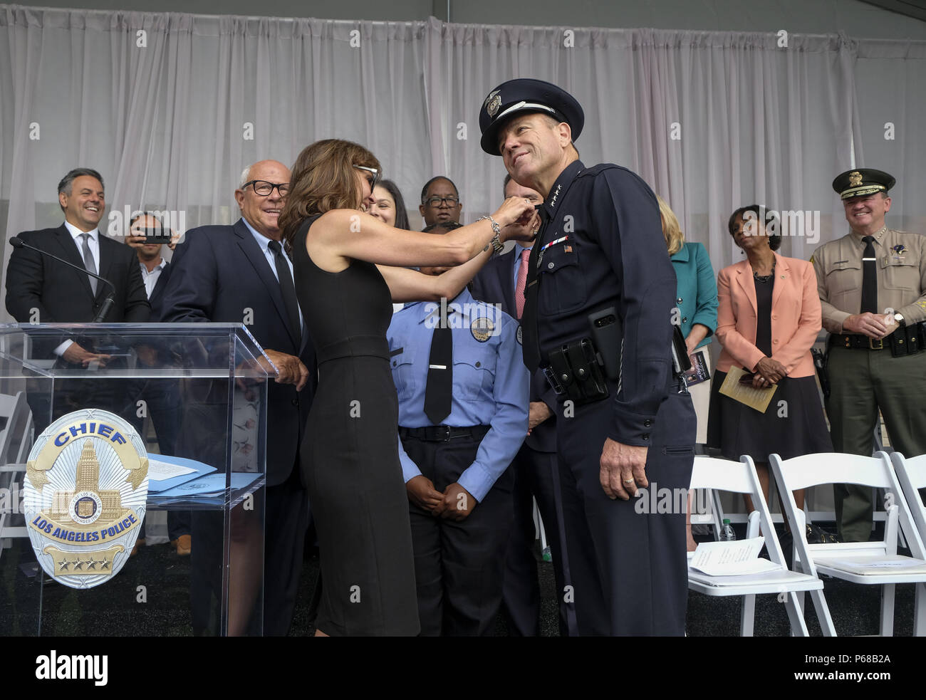 Los Angeles, Californie, USA. 28 Juin, 2018. Michel Moore a son insigne épinglé sur sa chemise de son épouse Cindy, après qu'il a été assermenté à titre de nouveau chef de Los Angeles à l'académie de police le jeudi 28 juin 2018. Moore remplace Charlie Beck, qui a pris sa retraite Mercredi, 27 juin 2018, après plus de 40 ans avec le LAPD. Ringo : crédit Chiu/ZUMA/Alamy Fil Live News Banque D'Images