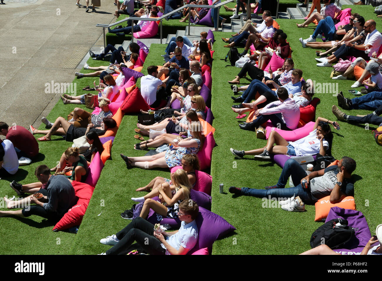 Grenier Square. Londres. Royaume-uni 29 juin 2018 - les travailleurs de la ville et les touristes profiter une autre journée chaude dans le grenier Square, Londres près de Regents Canal assis sur des coussins colorés tout en regardant le Roi Lion film sur un grand écran LED. Selon le Met Office, Juin a été le mois le plus sec jamais enregistré. Credit : Dinendra Haria/Alamy Live News Banque D'Images