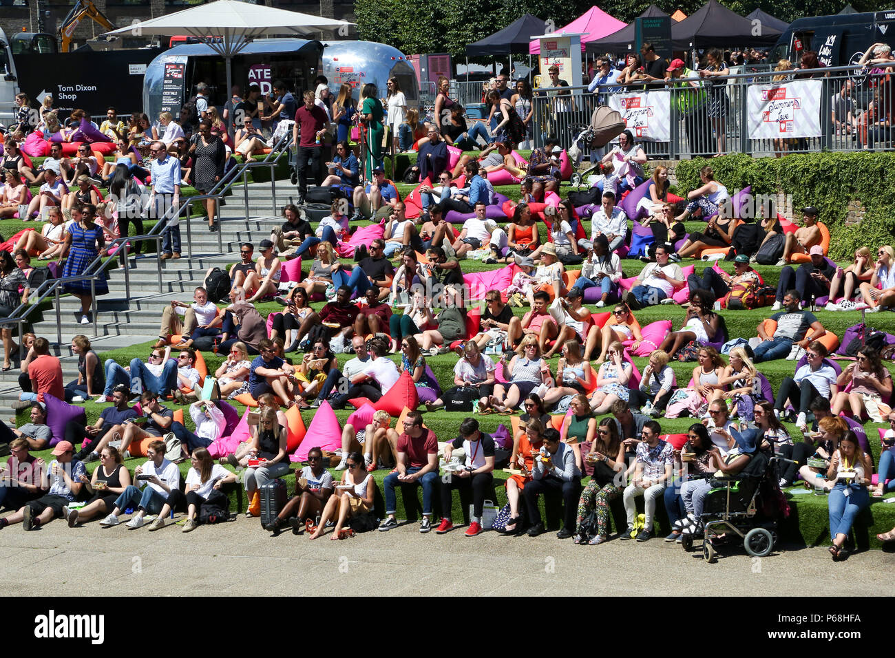 Grenier Square. Londres. Royaume-uni 29 juin 2018 - les travailleurs de la ville et les touristes profiter une autre journée chaude dans le grenier Square, Londres près de Regents Canal assis sur des coussins colorés tout en regardant le Roi Lion film sur un grand écran LED. Selon le Met Office, Juin a été le mois le plus sec jamais enregistré. Credit : Dinendra Haria/Alamy Live News Banque D'Images