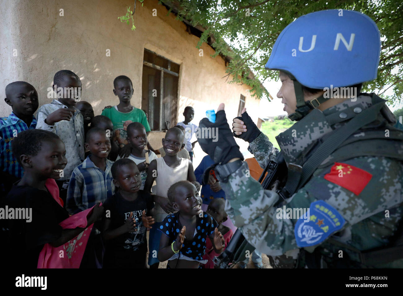 (180629) -- JUBA, 29 juin 2018 (Xinhua) -- Le soldat chinois Yu Peijie (R) chante des chansons avec les enfants à Juba, au Soudan du Sud, le 30 avril 2018. Peijie Yu, 26 ans, est le chef de l'unité de soldat de la femelle d'infanterie bataillon de maintien de la paix chinois au Soudan du Sud. Elle a un surnom appelé 'strong frère aîné." Cependant, elle a aussi un coeur doux. Cette année marque le 70e anniversaire du maintien de la paix des Nations Unies. La Chine a commencé ses participations dans les opérations de maintien de la paix des Nations Unies en 1990. Aujourd'hui, la Chine a quelque 2 500 casques bleus et joue un rôle important dans la promotion et le maintien de la Banque D'Images