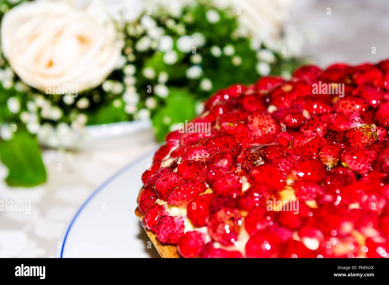 Gâteau aux fraises avec des fleurs dans l'arrière-plan Banque D'Images