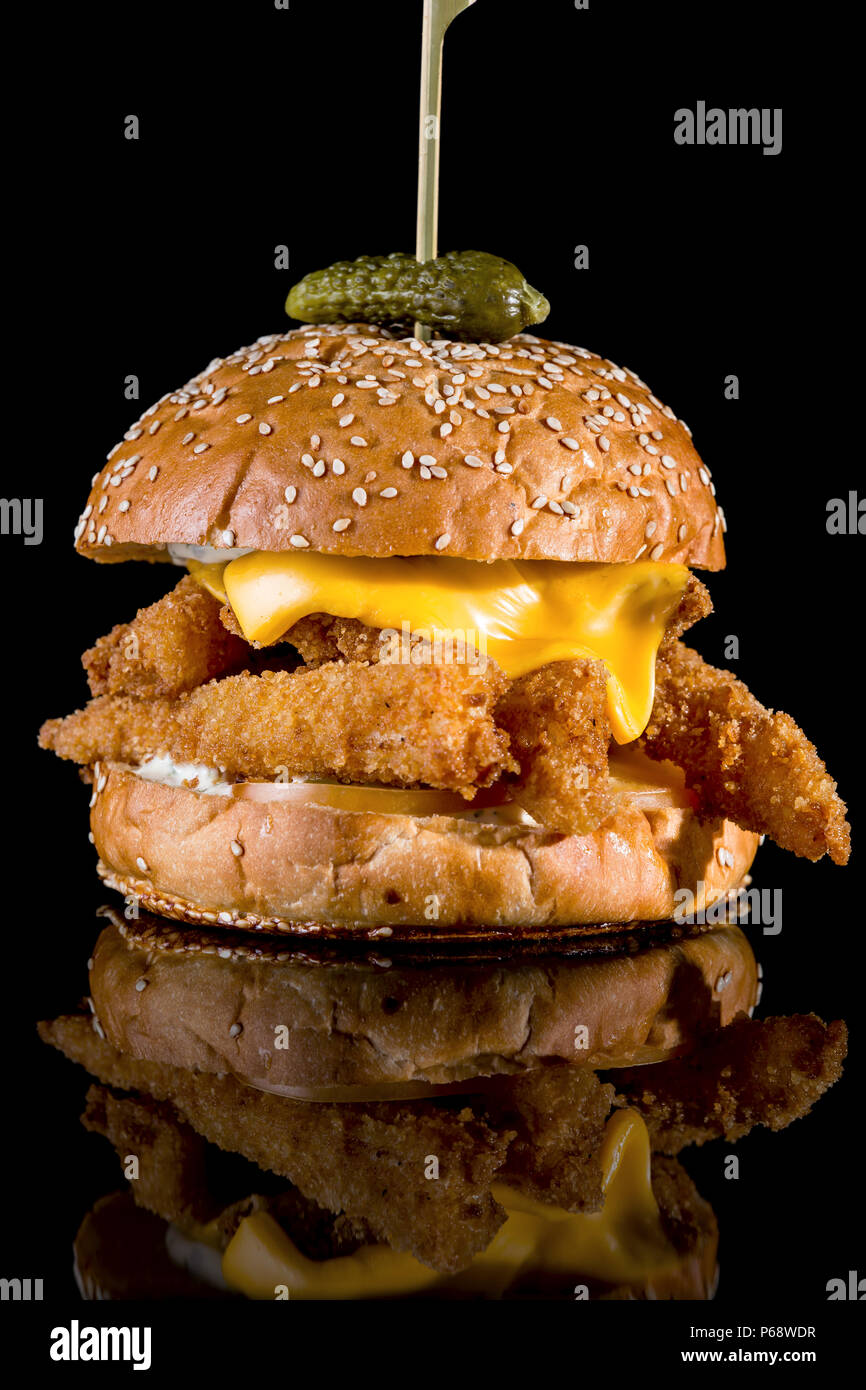 Burger King Fisher - Filets de poisson panés, tranche de fromage américain et sauce tartare avec réflexion isolé sur fond noir Banque D'Images