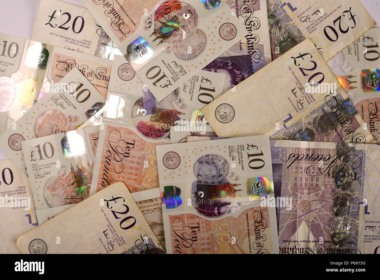 Un grand nombre de devises UK et dix billets de vingt livres comme image de fond. Banque D'Images