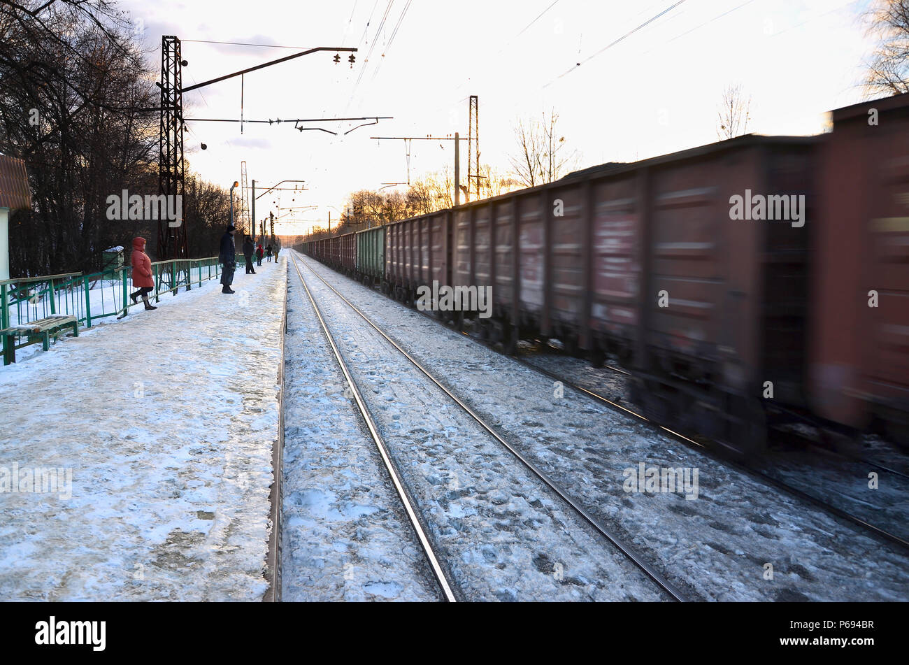 Photo de lumineux et beau coucher de soleil sur un ciel nuageux en saison froide d'hiver. Voie de chemin de fer avec des plates-formes pour les trains en attente de transmission de puissance et de lin Banque D'Images