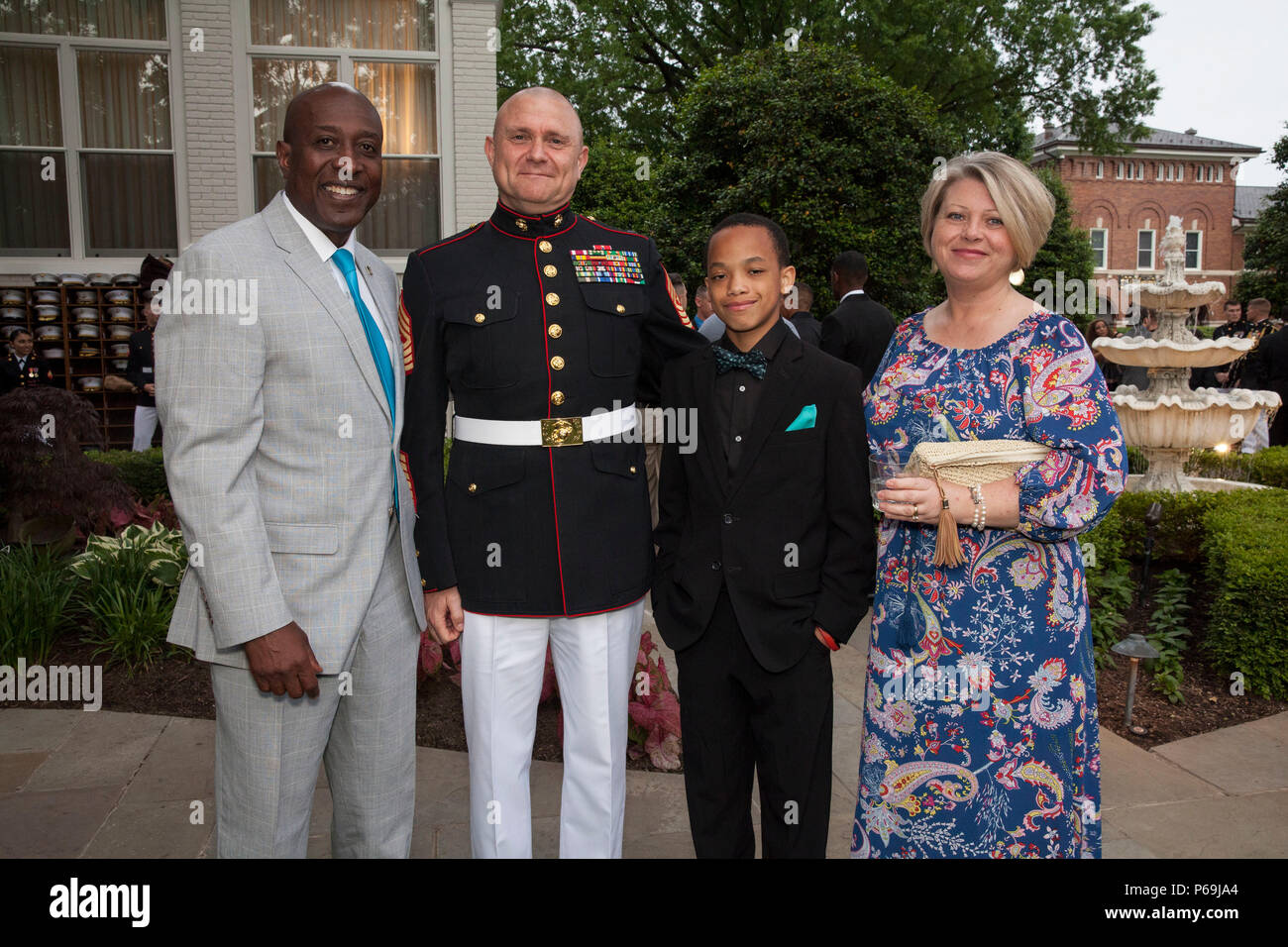 De gauche, Carlton W. Kent, 16e Sergent-major de l'U.S. Marine Corps, Sgt. Le major Robert. B. Pullen, sergent-major de commandement de bataillon de commandement et des Services, Corey Kent, fils de Carlton W., Kent et Melissa R. Pullen, épouse de Sgt. Le major Pullen, posent pour une photo lors d'une réception avant une soirée défilé au domicile des commandants, Washington, D.C., le 20 mai 2016. Le soir de l'été tradition parade en 1934 et silencieuse de l'offre, le U.S. Marine Band, le U.S. Marine Corps de tambours et clairons et deux compagnies de marche. Plus de 3 500 personnes assistent à la parade chaque w Banque D'Images