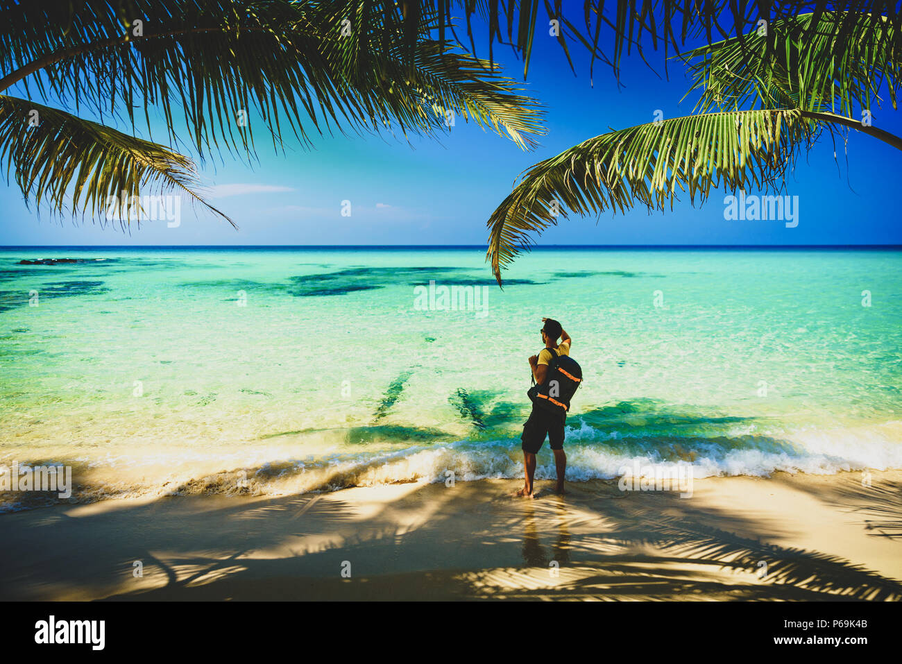 Photographe voyageur Silhouette avec sac à dos, debout près de la plage tropicale étonnante nature paysage en arrière-plan Banque D'Images