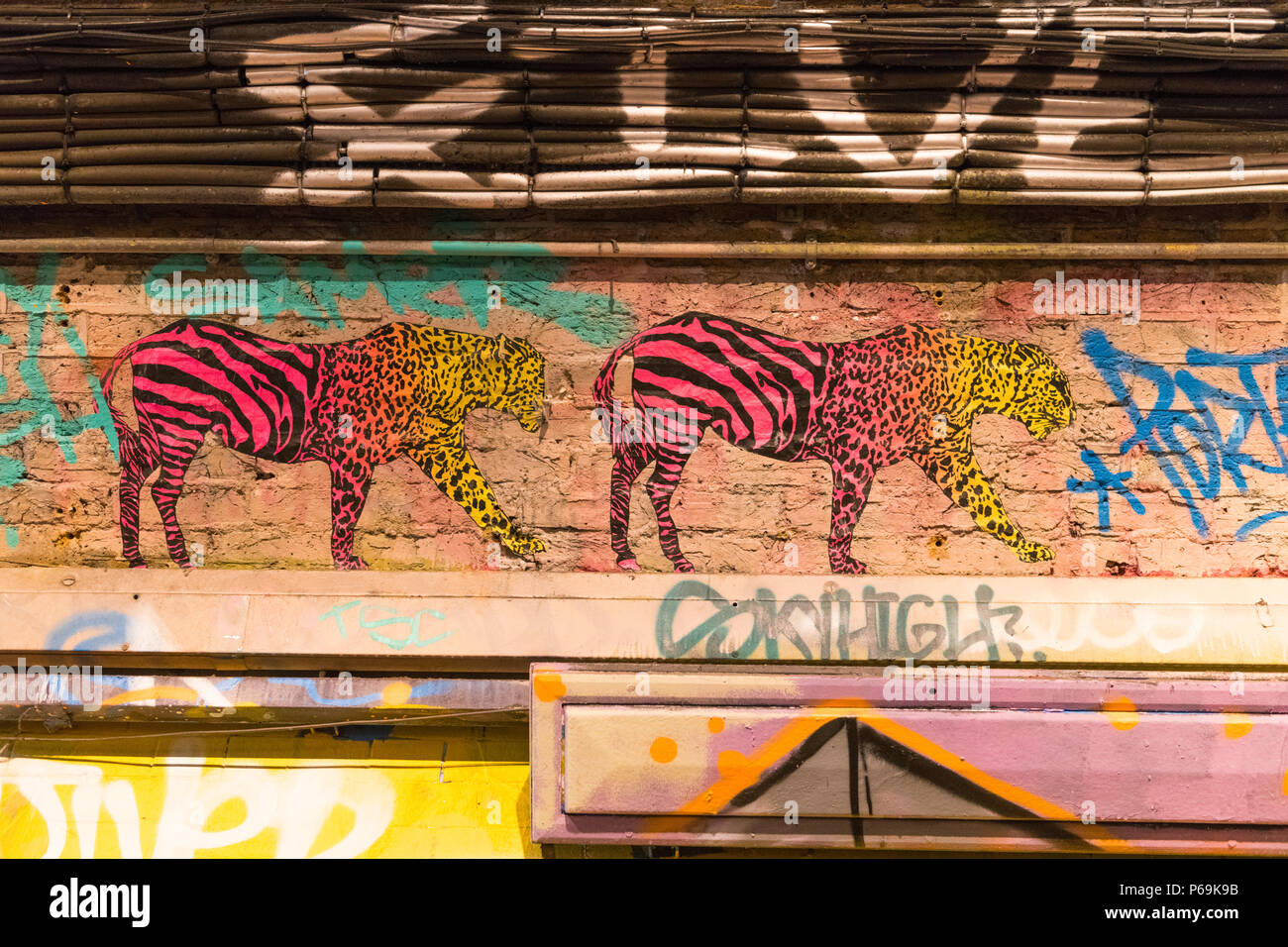 London Waterloo Leake Street 2 graffiti deux animaux partie partie rose rose & jaune zebra leopard cheetah on wall Banque D'Images