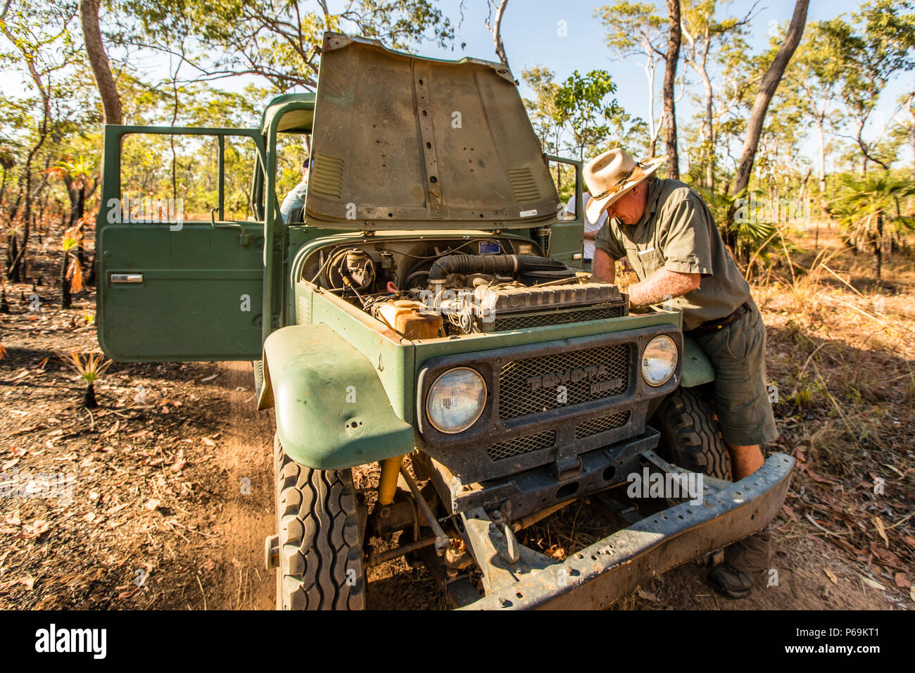 Sab Lord répare le moteur de son vieux Toyota Land Cruiser dans la brousse du Territoire du Nord, en Australie ; une boîte de répulsif contre les insectes hautement concentré donne à la courroie trapézoïdale l'adhérence dont elle a besoin Banque D'Images