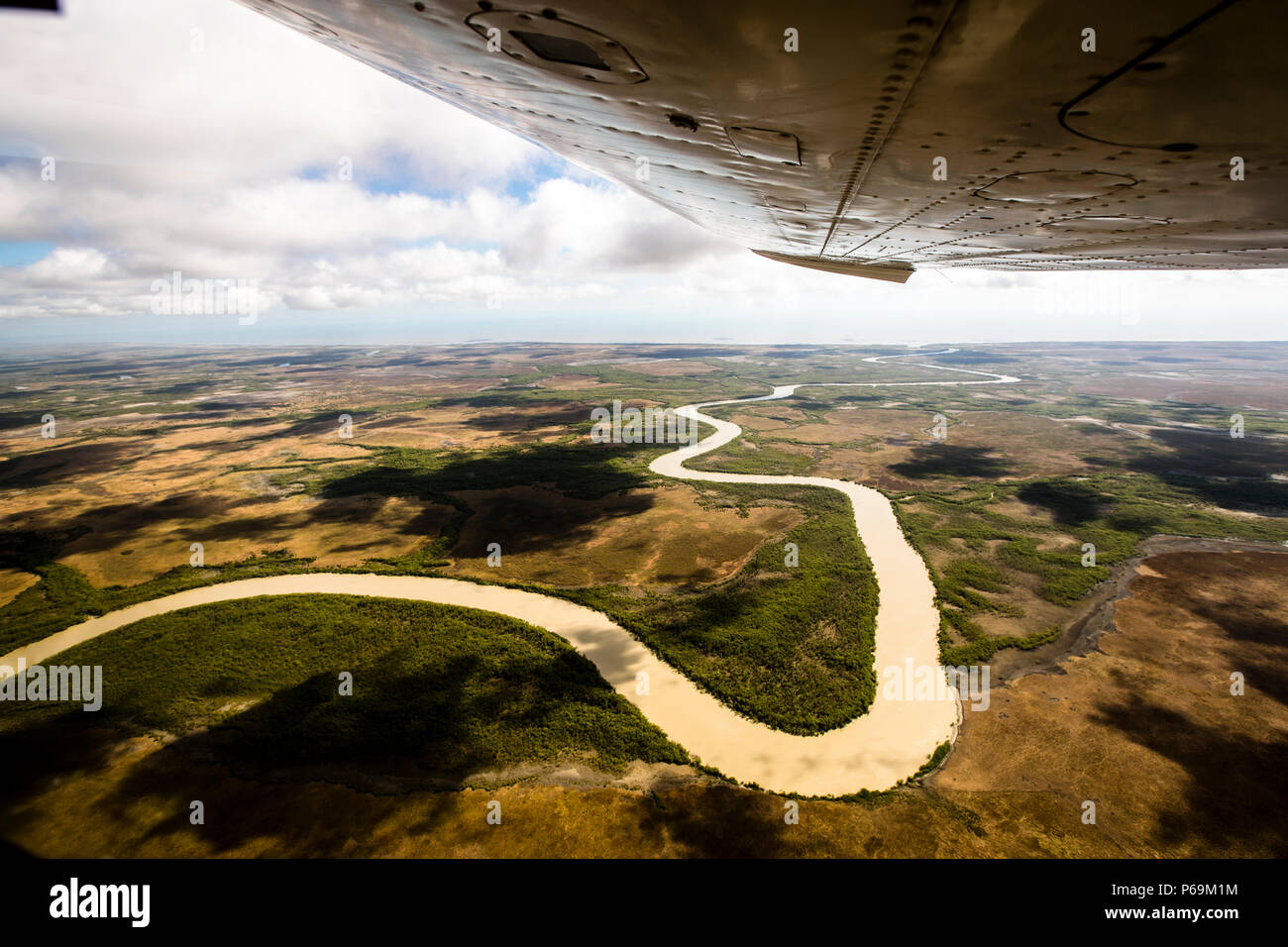 Une rivière sinueuse serpente à travers les marécages du Territoire du Nord, en Australie, photographiée depuis la fenêtre d’un petit avion survolant la région près de Point Stuart. Banque D'Images