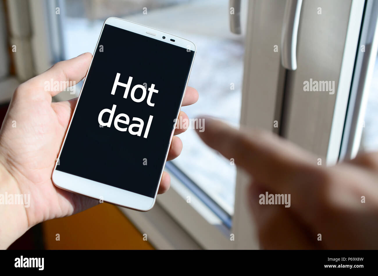 Une personne voit une inscription blanche sur un écran de smartphone noir qui tient dans sa main. Hot deal . Banque D'Images