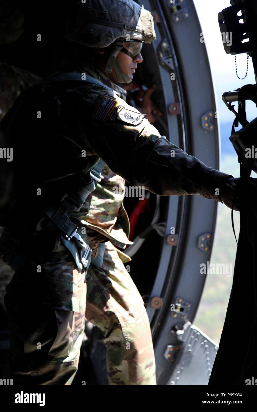 Le s.. Renaldo Lakharam se tient dans la porte d'un C-27 avions en attente de repérer les points de référence de 30 secondes avant de sortir un parachutiste au cours de la 4e Groupe de soutien de l'information militaire de saut de l'année, le 8 avril 2016. Lakharam, affectés au siège et de l'Administration centrale, la 4ème MISG, et deux autres jumpmasters ont été testés sur leur forme physique, aptitude à effectuer des fonctions de saut en l'air et sur le sol, et au cours de la connaissance générale jumpmaster plusieurs jours en concours. Lakharam a été annoncé le lauréat au cours d'une cérémonie de remise de prix le 20 mai 2016. Banque D'Images