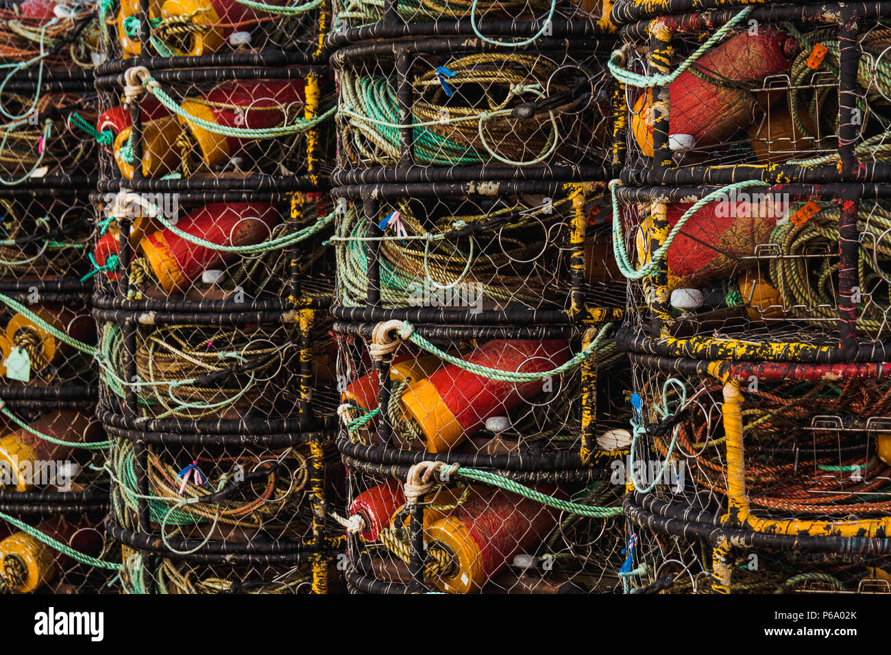 Gros plan de vol en crabe pots empilés de façon uniforme dans une rangée près d'un bâtiment dans la région de Newport sur la côte de l'oregon dans une baie. Banque D'Images