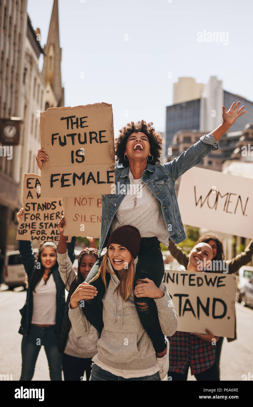 Groupe de manifestants bénéficiant au cours d'une Marche des femmes avec des panneaux. Laughing women holding pancartes pour l'avenir et l'autonomisation des femmes. Banque D'Images