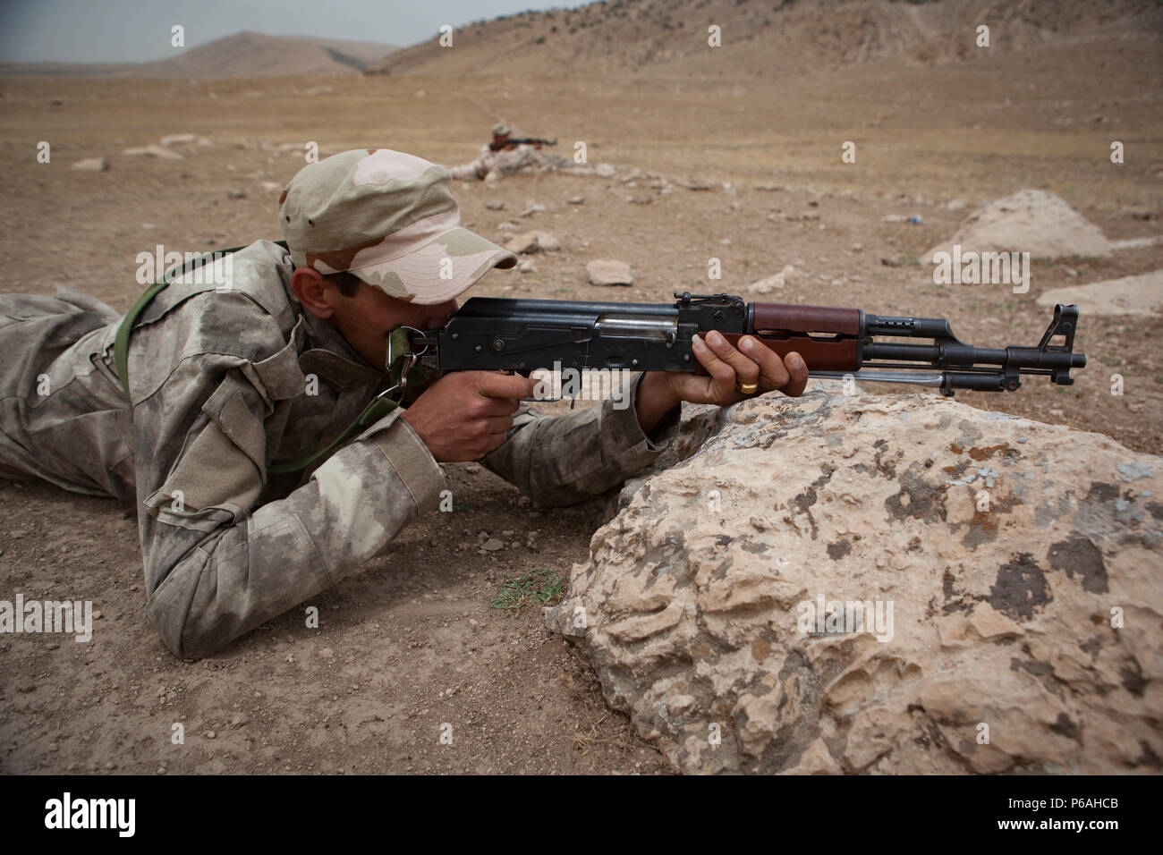 Un soldat de l'Unité de Protection de la Plaine de Ninive se met à couvert et retourne incendie simulé au cours de la formation, ils réagissent au contact de leur centre de formation à la province de Ninive, le 18 mai 2016. La NPPU est un petit groupe de combattants qui sont venus ensemble pour protéger leur peuple dans la lutte contre l'Etat islamique d'Irak et du Levant. La formation est axée sur l'Équipe spéciale mixte - fonctionnement inhérentes à l'ensemble de la mission de résoudre renforcer les capacités des partenaires et d'accroître la capacité militaire des forces locales combats ISIL. (U.S. Photo de l'armée par le sergent. Sergio Rangel/libérés) Banque D'Images