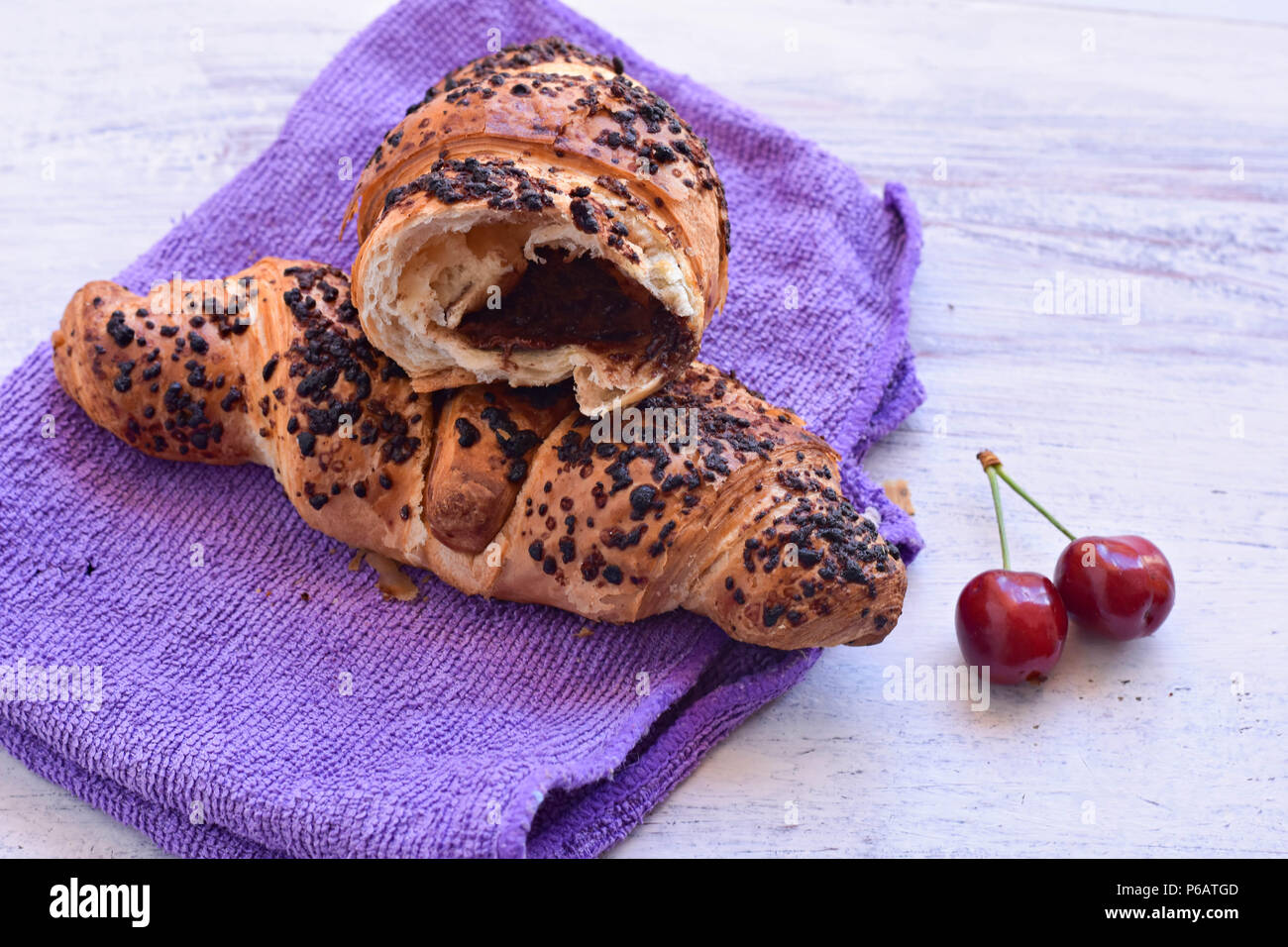 Pain au chocolat et cerises au fond en bois// fond Petit-déjeuner Petit-déjeuner sucré/ partir un jour Banque D'Images