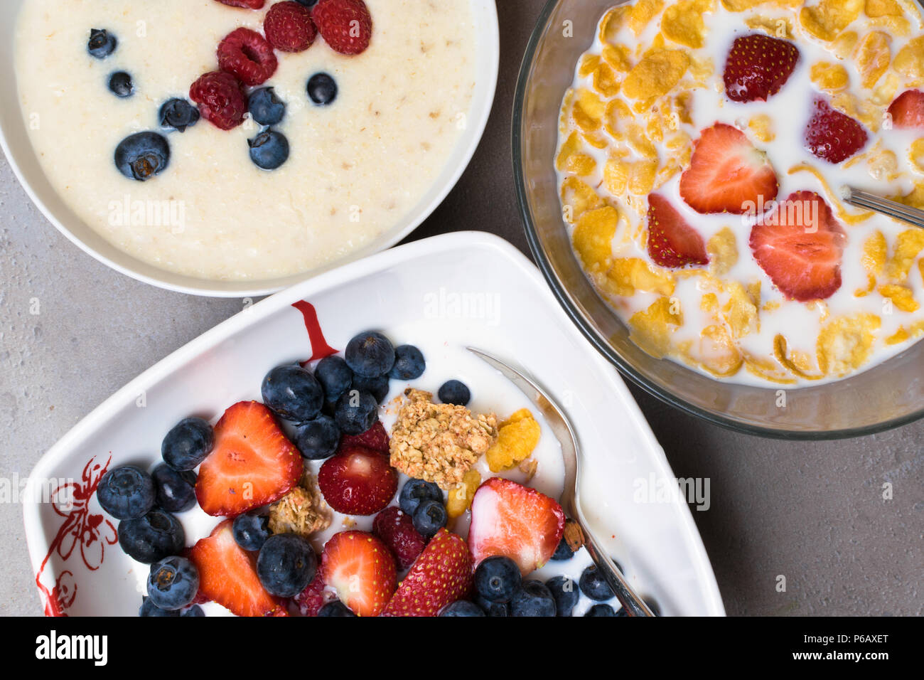 Petit déjeuner végétarien. bol de céréales d'avoine avec du lait cru, framboises, bleuets, fraises, et les écrous avec cuillère pour petit-déjeuner sain et avokado Banque D'Images