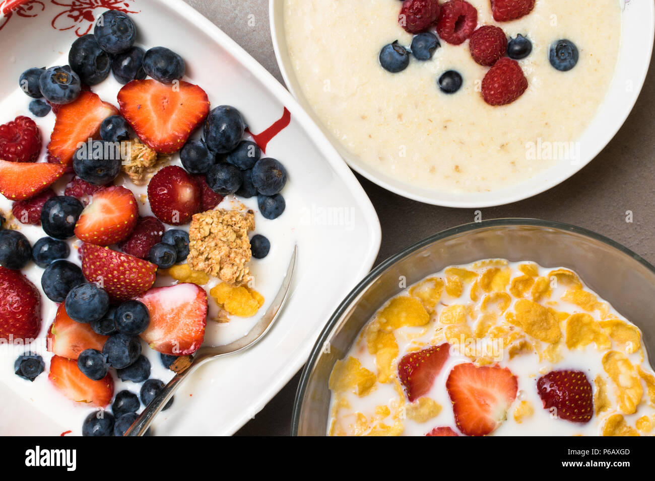 Petit déjeuner végétarien. bol de céréales d'avoine avec du lait cru, framboises, bleuets, fraises, et les écrous avec cuillère pour petit-déjeuner sain et avokado Banque D'Images