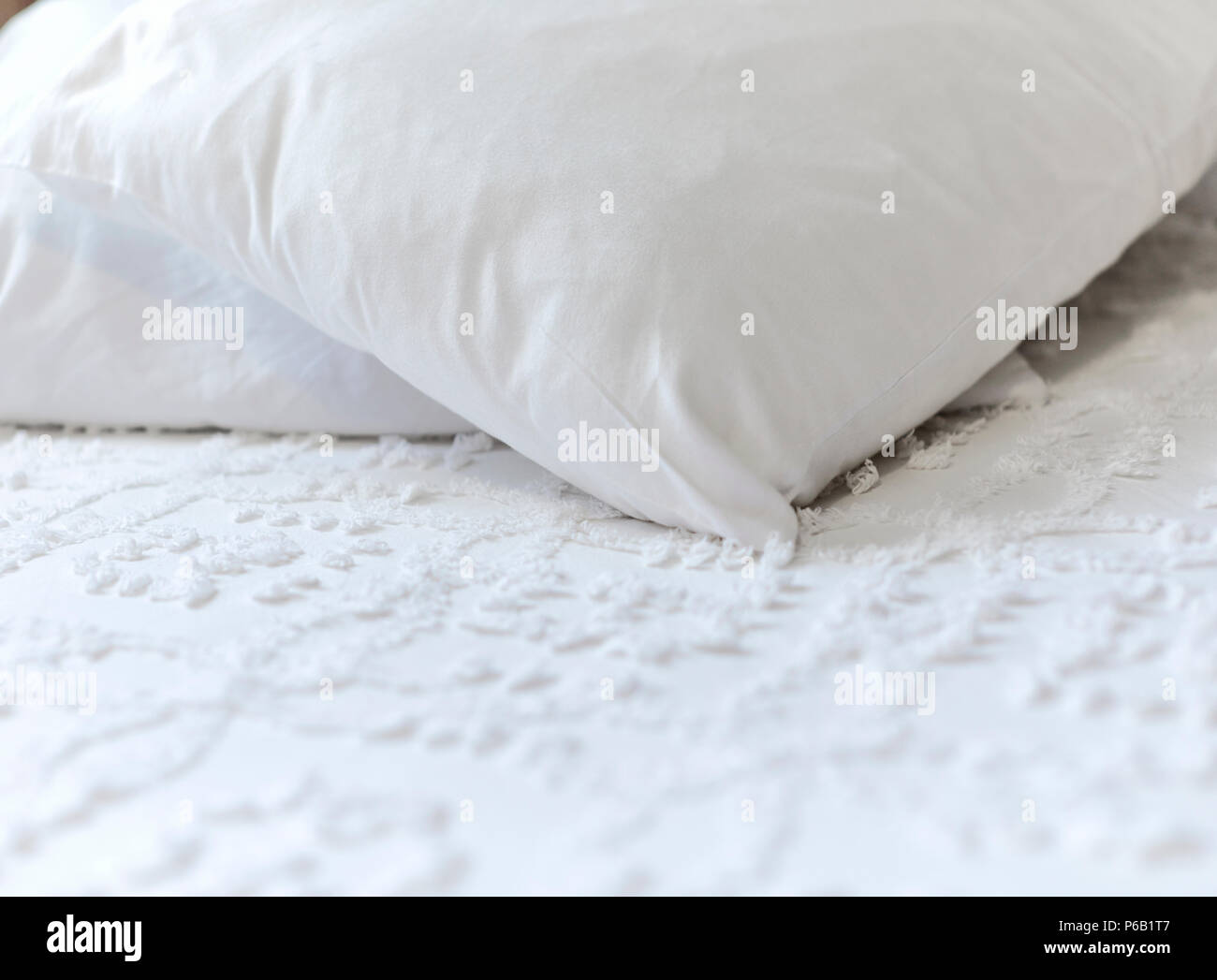 Oreillers blanc portant sur un couvre-lit blanc avec une faible profondeur de champ Banque D'Images
