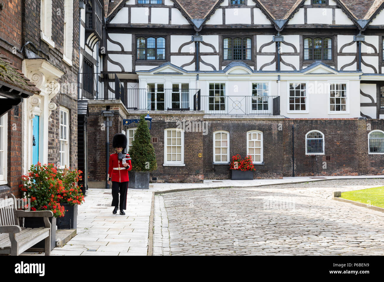 London,UK - 7 juin 2017 : Chalets et quartiers résidentiel à l'intérieur de la Tour de Londres. Un garde en uniforme rouge et noir traditionnel, des marches d'alon Banque D'Images