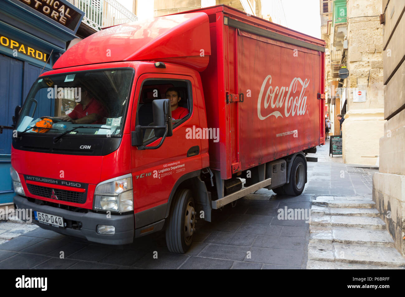 Coca Cola camion / camion dans les rues étroites et les routes de l'historique vieille ville de La Valette, Malte, alors qu'il fait ses livraisons de cola et fait des collections de bouteilles vides. Banque D'Images