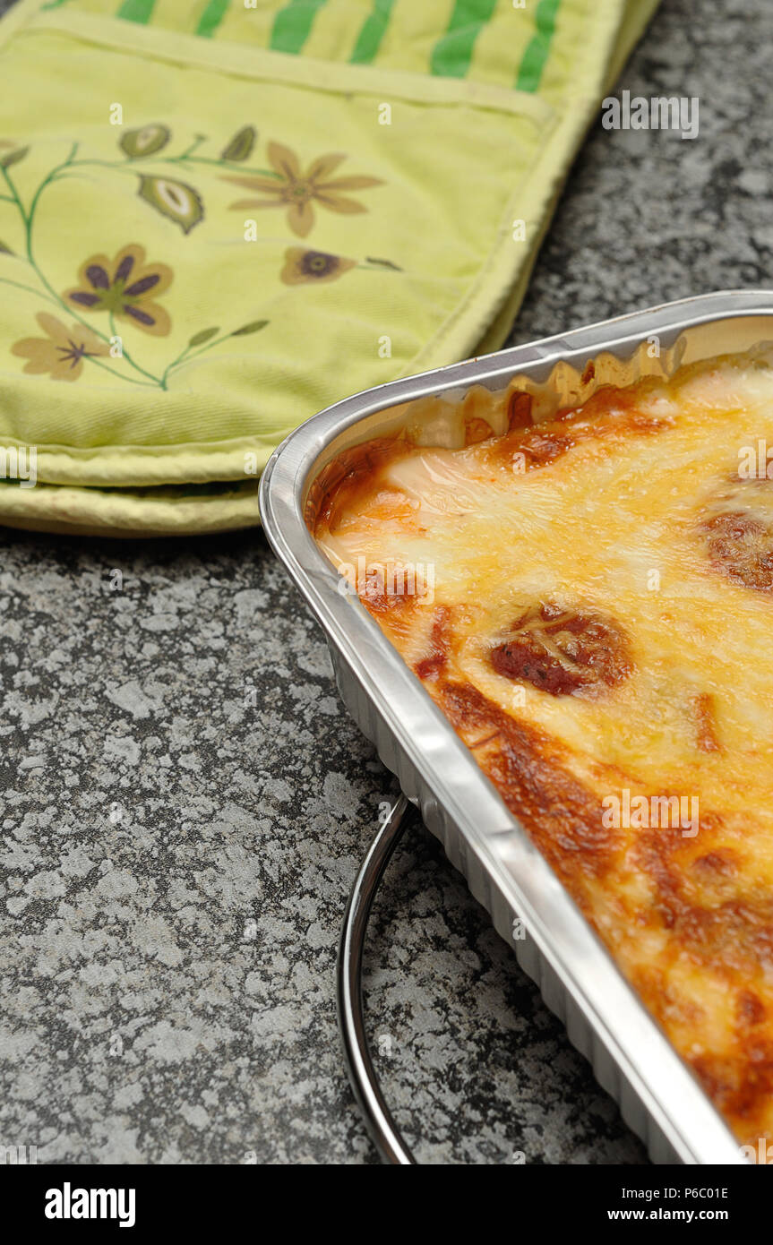 Un golden brown affiche dans une lasagne au four d'aluminium sur un top cuisine Banque D'Images