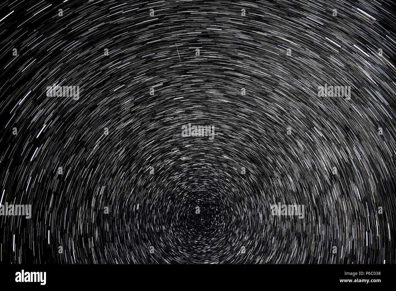 Espace abstrait arrière-plan avec des traces d'étoiles tournant autour d'une étoile polaire, sous la forme de pistes circulaire noir sur fond de ciel nocturne Banque D'Images