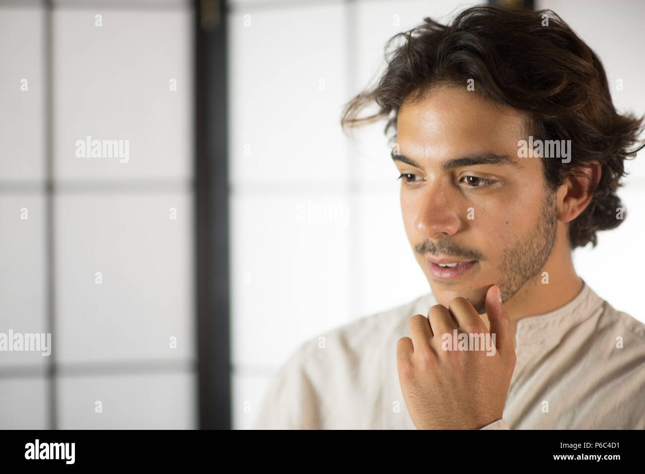 Close Up of Young Man de toucher son menton Banque D'Images