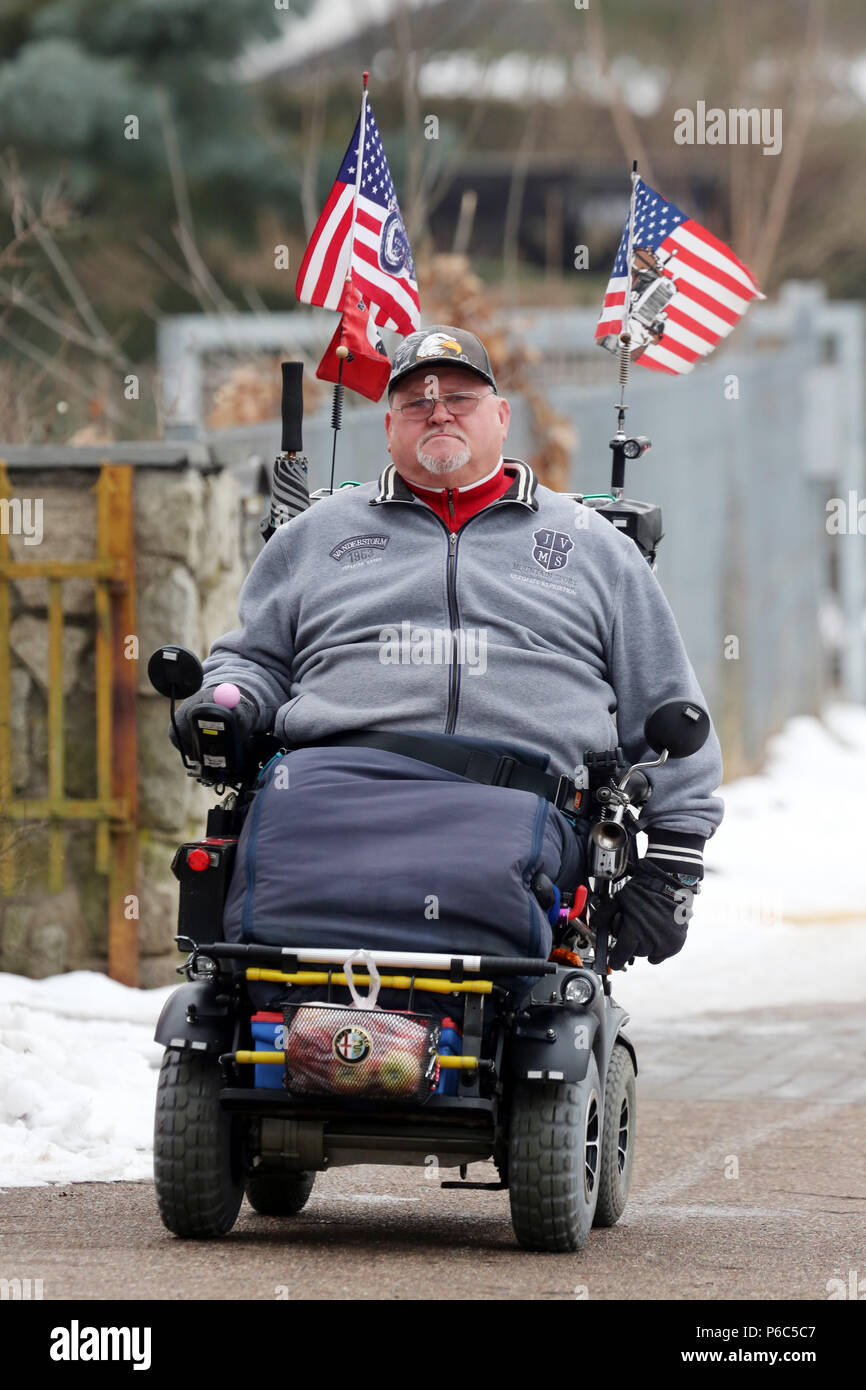 Neuenhagen, l'homme conduit son fauteuil roulant électrique battant pavillon des États-Unis et le jour de l'assermentation du président américain Donald Trump Banque D'Images