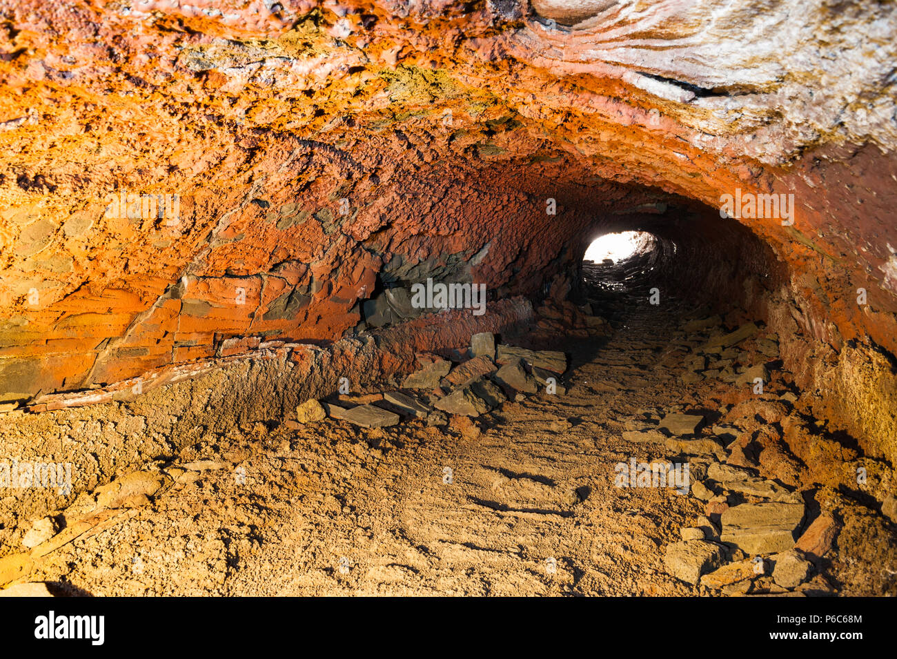 Craggy roches formant une grotte de lave éclairés par la lumière artificielle, capturés lors d'une exposition longue durée offre contrastée couleurs orange, l'islande avril 2018 Banque D'Images