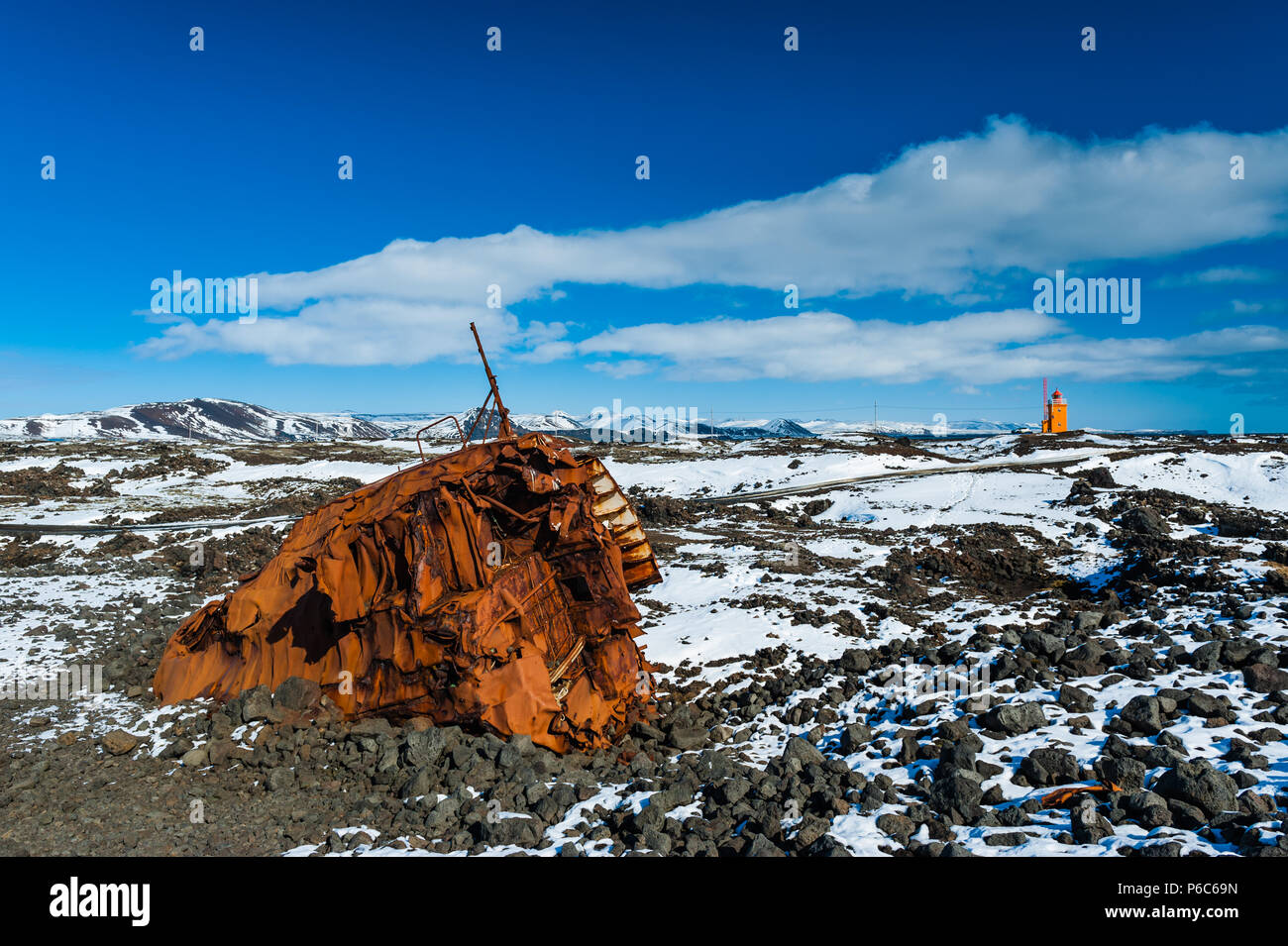 Coque de navire déformé au cimetière couvert de navire Grindavik l'emblématique maison lumière orange à l'arrière-plan, l'islande avril 2018 Banque D'Images