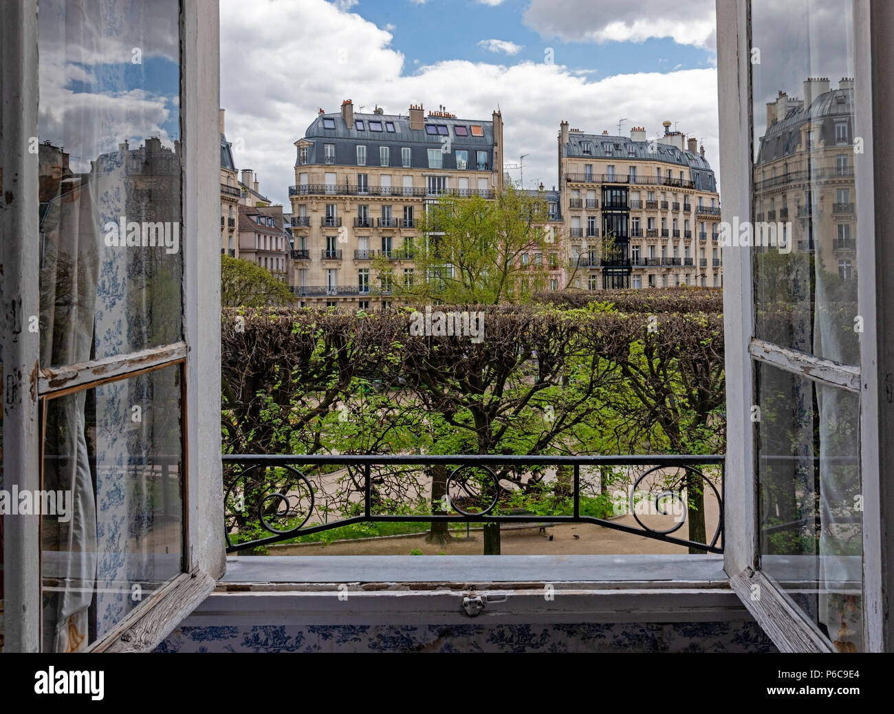 Vue depuis une porte-fenêtre ouvrant sur la chambre avec vue sur les bâtiments à l'architecture Second Empire. Banque D'Images