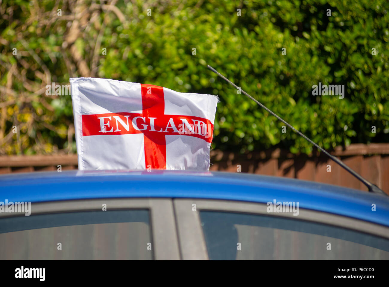 Drapeau rouge et blanc Angleterre battant sur le toit d'une voiture bleue pendant la Coupe du Monde de Football 2018 Banque D'Images