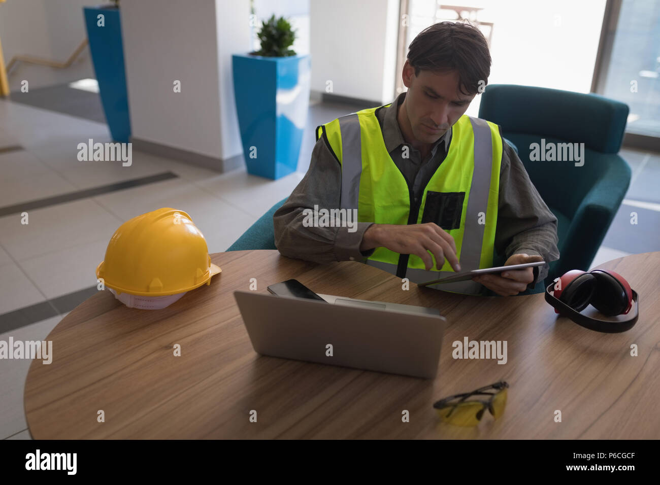 Male worker using digital tablet at desk Banque D'Images