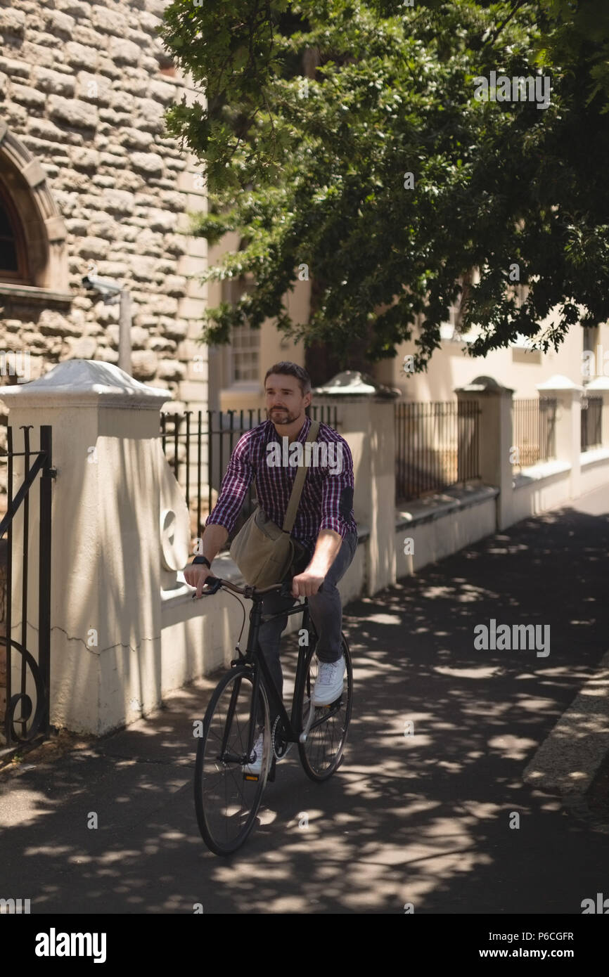 Man riding bicycle on street Banque D'Images