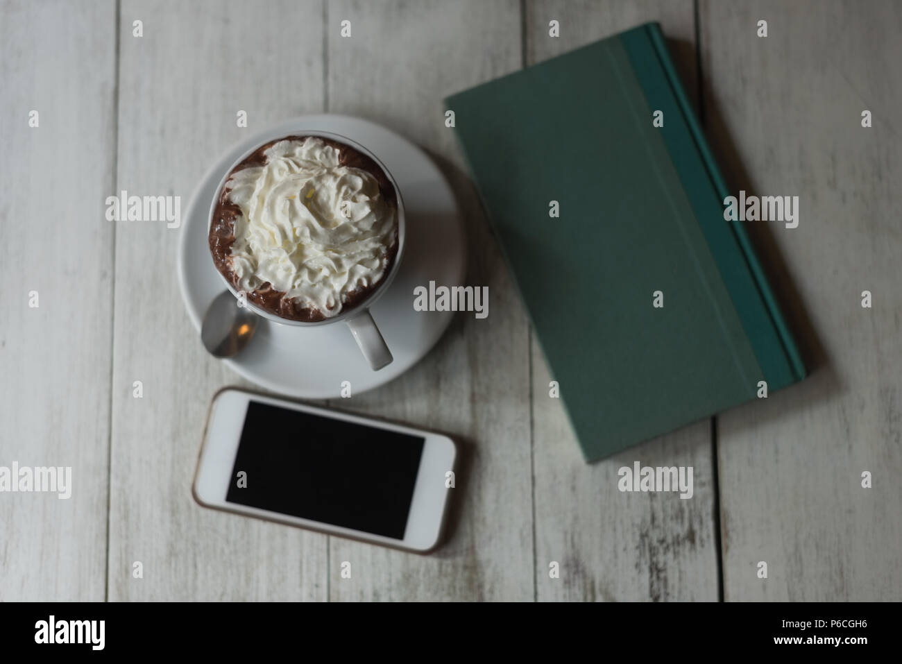 Un aliment sucré, agenda et téléphone mobile sur table en bois Banque D'Images