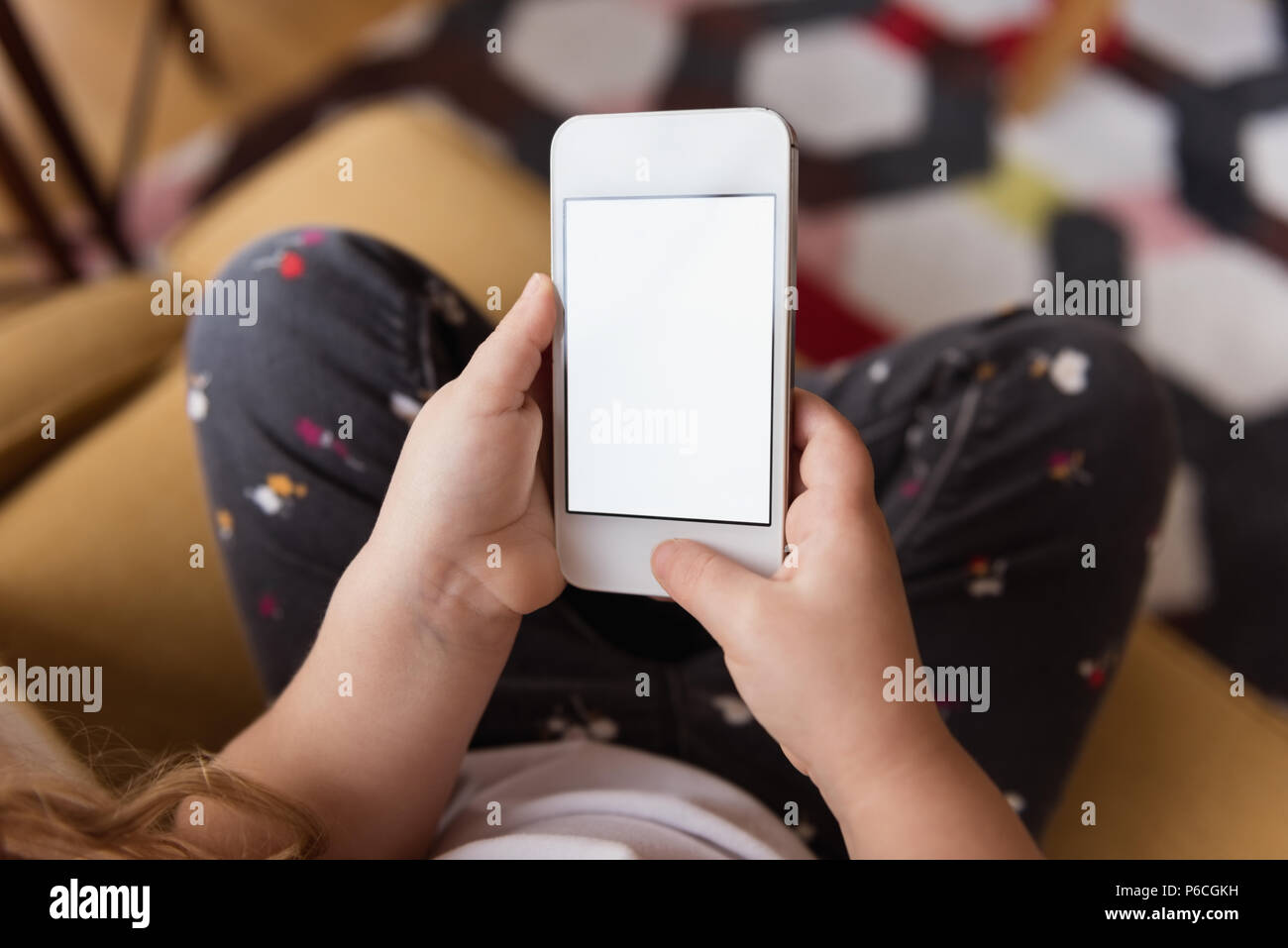 Girl using mobile phone at home Banque D'Images