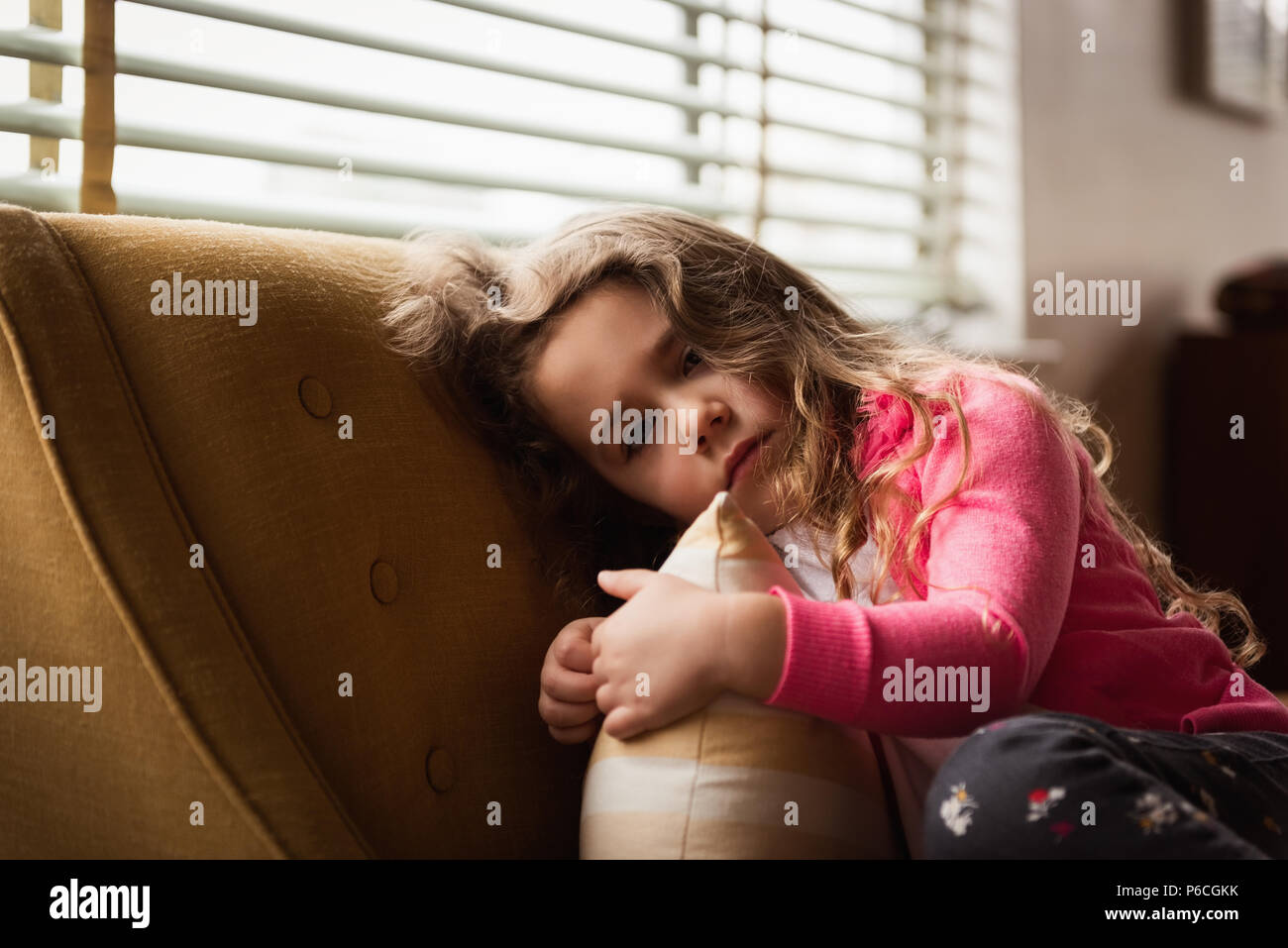Girl relaxing on sofa in living room Banque D'Images