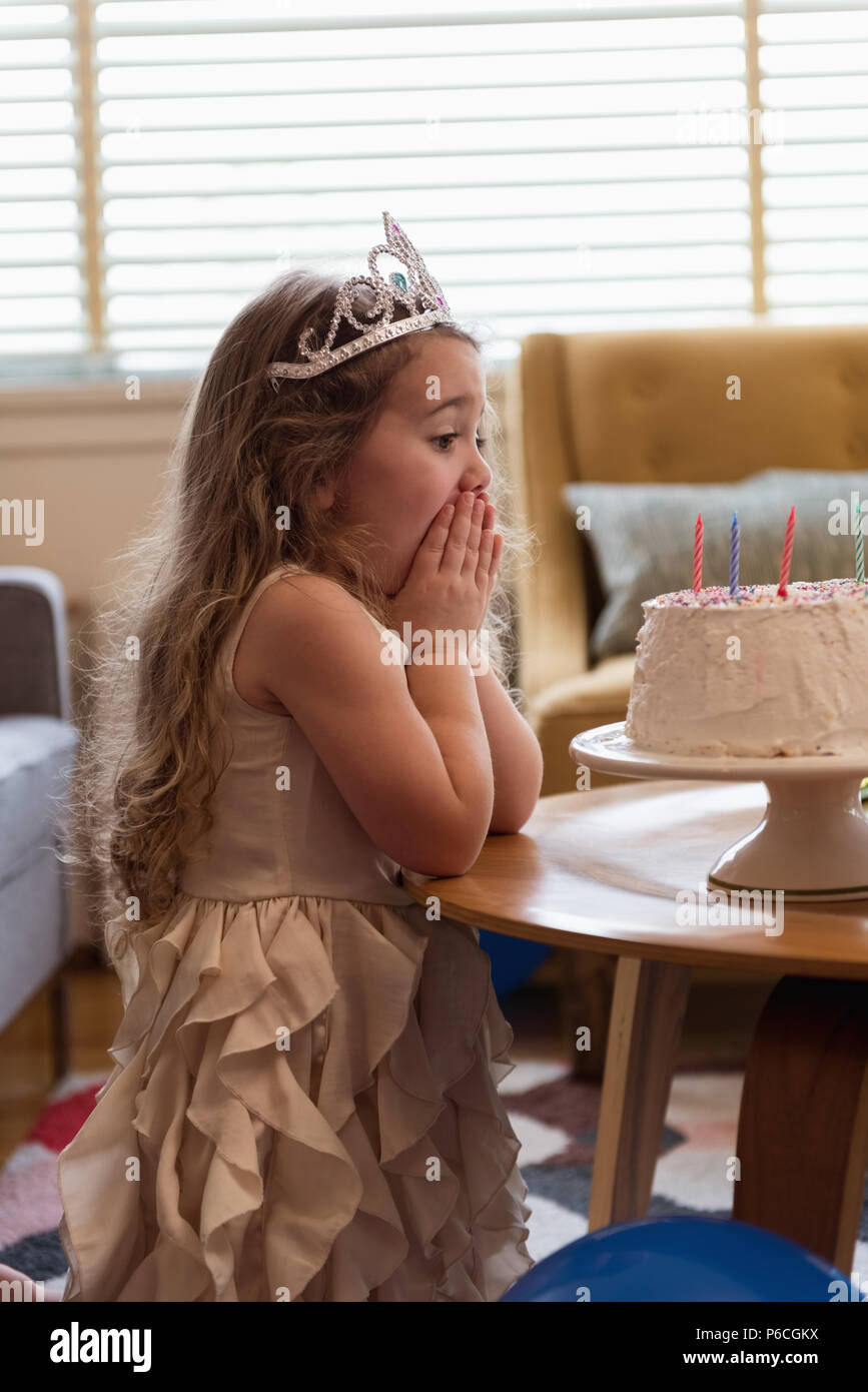Surpris girl looking at her birthday cake Banque D'Images