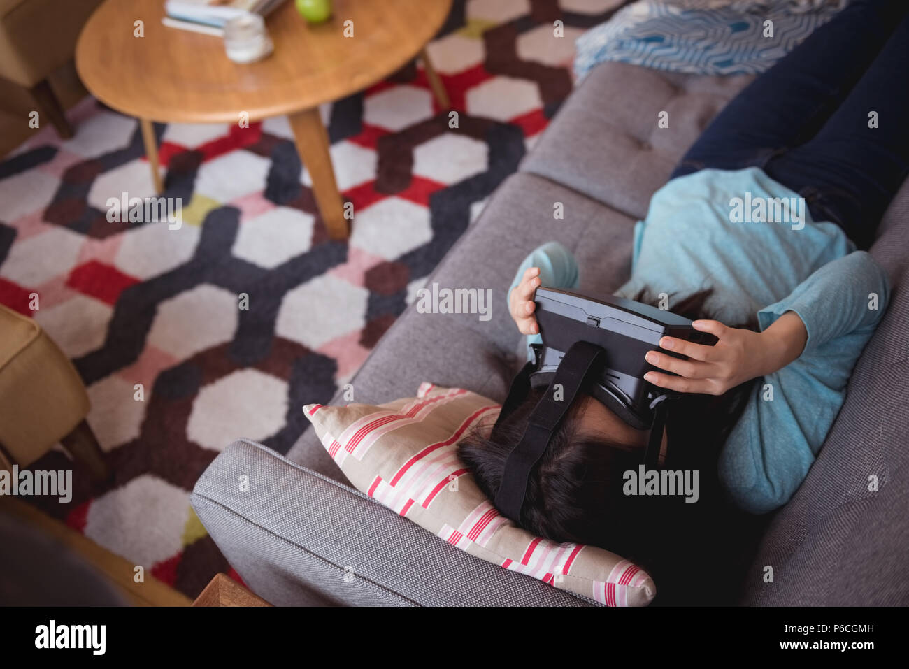 Femme à l'aide de casque de réalité virtuelle dans la salle de séjour Banque D'Images