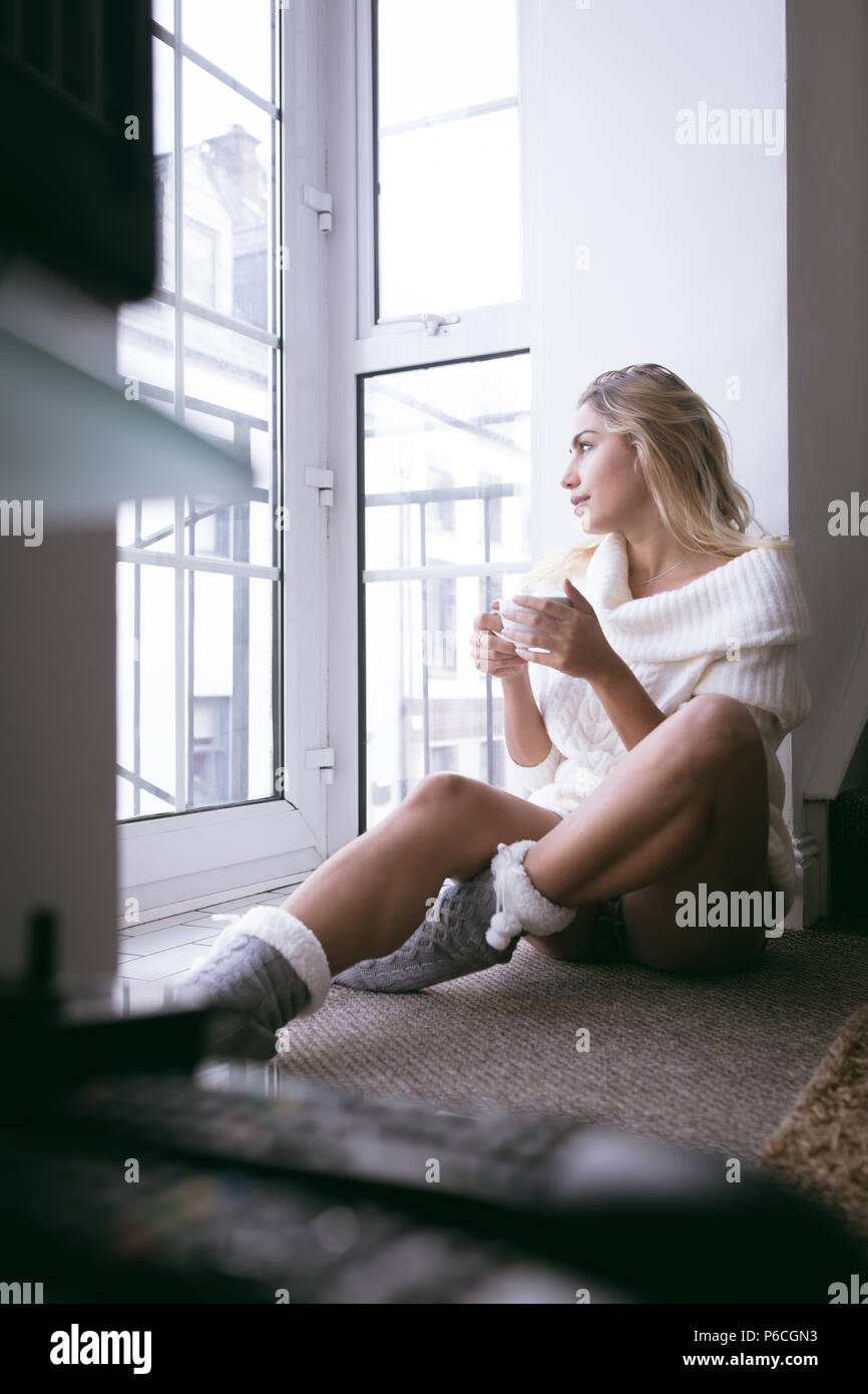 Femme ayant le thé vert à la maison Banque D'Images